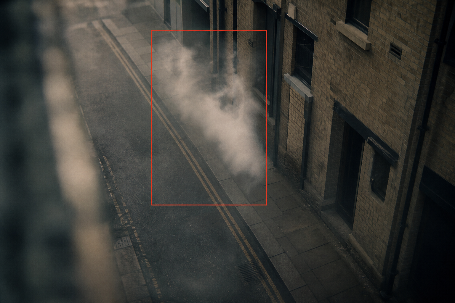 close-up of CCTV frame detecting a faint smoke wisp near an outlet in a retail stockroom